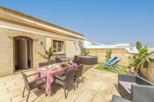 a patio with a table and chairs on a patio at Palazzo Lily in Racale