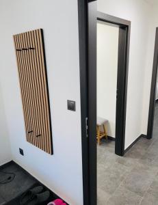 Dvojlůžkový pokoj s vlastní koupelnou في Petrovice: غرفة بها مرآتان وباب به أحذية