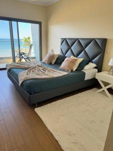 a bedroom with a large bed with a view of the ocean at Brisa do Mar - 2BR Sea Front Luxury Apartment in Quarteira