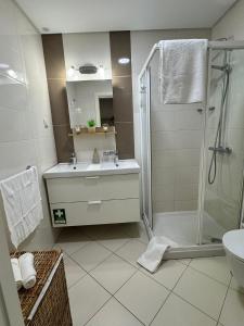 a bathroom with a shower and a sink and a toilet at Brisa do Mar - 2BR Sea Front Luxury Apartment in Quarteira +17 photos