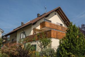 a house with a large deck on top of it at Ferienwohnung Monika Haug in Immenstaad am Bodensee