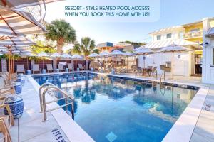 una gran piscina con sillas y sombrillas en The Big Tybreezy, en Tybee Island