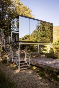a glass house on a wooden bridge with stairs at Spino Fiorito Stay in Casola in Lunigiana