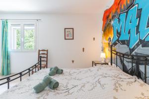 a bedroom with a bed with a painting on the wall at Mas Provençal in Saint-Rémy-de-Provence +22 photos