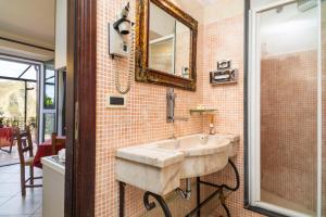 a bathroom with a sink and a mirror at Garden Cottage I Dammusi - Ulivo in Castelmola +11 photos