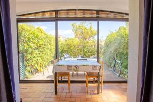 a dining room with a table and chairs on a patio at Les Tulipes in Carqueiranne