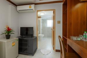 a room with a bathroom with a television and a toilet at Break Point Patong Hotel in Patong Beach +16 photos