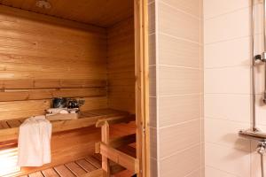 a sauna with a shower and a sink at Modern Aurora Apartment with Sauna - Rovaniemi by Book Lapland in Rovaniemi