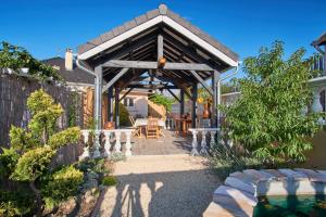 eine Pergola mit einem Tisch und Stühlen im Hof in der Unterkunft Au Clair Matin à La Mure in Pierre-Châtel