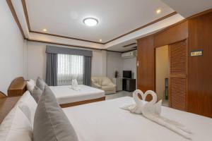 a bedroom with two beds with white sheets at Break Point Patong Hotel in Patong Beach