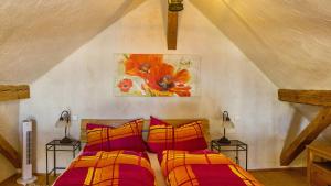 a bedroom with two beds and a painting on the wall at Ferienwohnungen Altes Rathaus in Vogtsburg