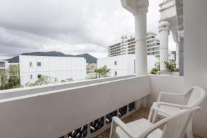 a balcony with two chairs and a view of a city at Break Point Patong Hotel in Patong Beach