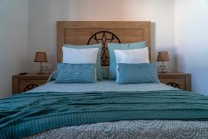 拉穆埃拉Casa Miramar的卧室里有一张大床，配有蓝白相间的枕头 更多22张照片