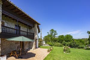 a patio with an umbrella next to a building at Casa María Mérica in Llanes