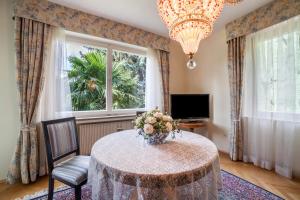 une salle à manger avec une table avec un vase de fleurs dans l'établissement Villa Coris Ferienwohnung Magnolia, à Merano