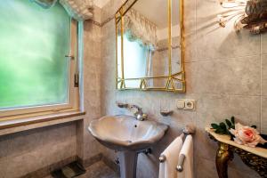 une salle de bain avec un lavabo et un miroir dans l'établissement Villa Coris Ferienwohnung Magnolia, à Merano 16 autres photos