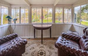 a room with two couches and a table and windows at 4 Bedroom Nice Home In Nybro in Pukeberg