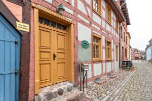 un groupe de bâtiments avec portes jaunes dans une rue dans l'établissement ruhig gelegene Ferienwohnung, à Röbel
