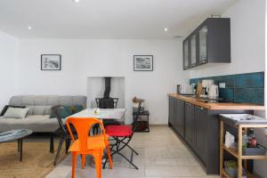 a kitchen and living room with a table and chairs at Charmante maison de pecheur in Ploubazlanec