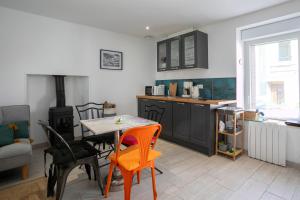 a kitchen with a table and chairs and a stove at Charmante maison de pecheur in Ploubazlanec +12 photos
