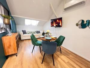 ein Wohnzimmer mit einem Tisch und grünen Stühlen in der Unterkunft E - Le loft in Epernay T2 au cœur du centre ville in Épernay