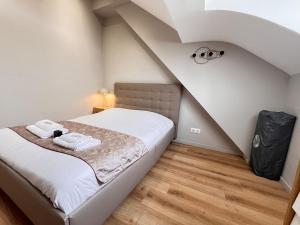ein kleines Schlafzimmer mit einem Bett im Dachgeschoss in der Unterkunft E - Le loft in Epernay T2 au cœur du centre ville in Épernay