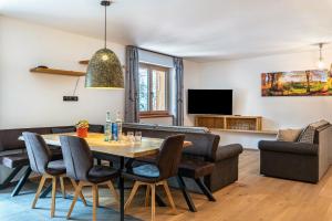 コッラルボにあるSchartneralm Fichteのテーブルと椅子とソファのあるリビングルーム