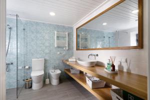 une salle de bain avec un lavabo, des toilettes et un miroir dans l'établissement Adega do Portinho Velho, à Piedade 36 autres photos