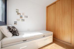 Bett in einem Zimmer mit Holztür in der Unterkunft Apartamento Lancelot in Puerto del Rosario + 20 Fotos