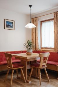 a dining room table with two chairs and a couch at Ciasa Willy App Lavarella in La Villa