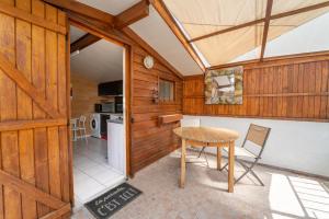 a dining room with a table and a kitchen at Clos des Fontaines - Chalet in Venasque