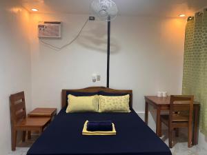 una camera con letto, tavolo e ventilatore di BaleCabugaoCottagesRental a El Nido