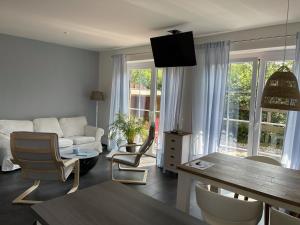un salon avec un canapé et une table dans l'établissement Haus Am Dorfteich B eingefriedet, à Fehmarn