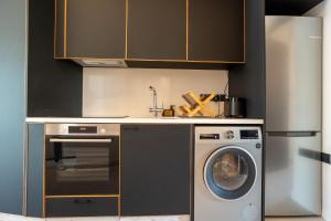 a kitchen with a washing machine and a refrigerator at Modern 2BR-Old Town Pafos in Paphos