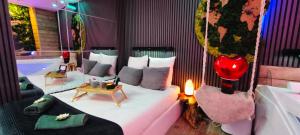 a bedroom with a white bed and a table at Eden SPA et Cinéma in Brie-Comte-Robert