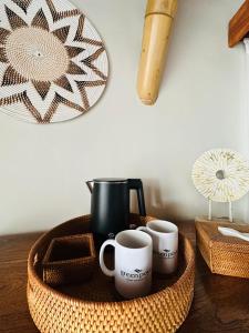 塞隆贝拉纳克Green Poya Resort and Spa的盘子,桌子上放着两个咖啡杯