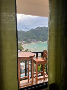 un tavolo e sedie su un balcone con vista sull'oceano di BaleCabugaoCottagesRental a El Nido