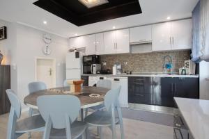 eine Küche mit einem Holztisch und weißen Schränken in der Unterkunft Praia Azul Beach and Sun in Silveira