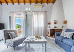 a living room with a blue couch and a fireplace at Milia Beach Apartments in Paralia Milia