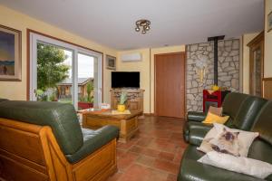 a living room with green leather furniture and a tv at Chez Les ours in Rochefort