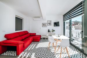 Una sala de estar con un sofá rojo y una mesa. en Eterna Primavera, en Adeje