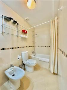 biała łazienka z toaletą i umywalką w obiekcie San Miguel centro de Torremolinos w mieście Torremolinos +16 zdjęć