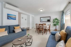 salon z niebieską kanapą i stołem w obiekcie San Miguel centro de Torremolinos w mieście Torremolinos