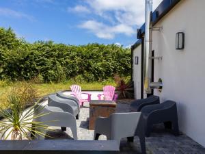 a group of chairs sitting on a patio at Le Gwern by Madame est Servie in Pleumeur-Bodou