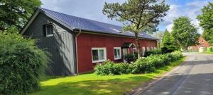 BondelumにあるFerienhaus Bondelumの通りの横に木がある赤と黒の家
