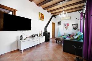 a living room with a couch and a flat screen tv at Villa Indie in Chiclana de la Frontera