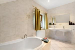 a white bathroom with a tub and a sink at Ferienhaus 'Zum Zaunkönig' in Luftkurort Lückendorf +20 photos