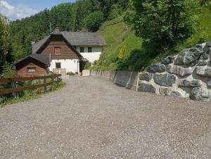 a building with a fence and a stone wall at Naturoase in Wolfsberg