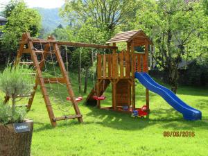 um parque infantil com um escorrega e um baloiço em Haus Füsslmühle em Fuschl am See