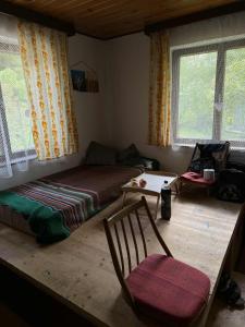 a living room with a bed and a chair and windows at Cozy cottage in the heart of Čičmany in Čičmany